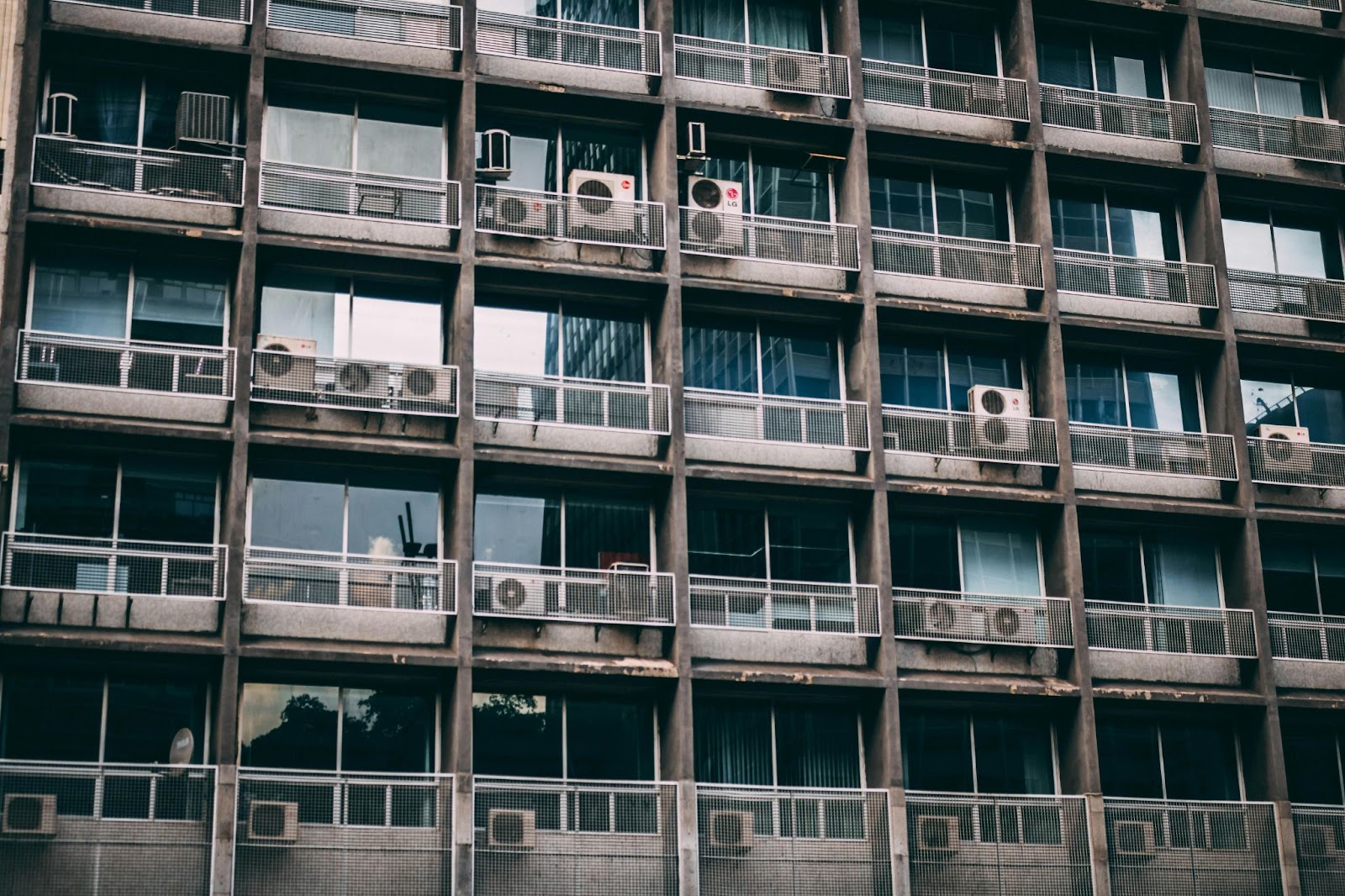 Air Conditioner units on outdoor racks on a multi-level apartment building