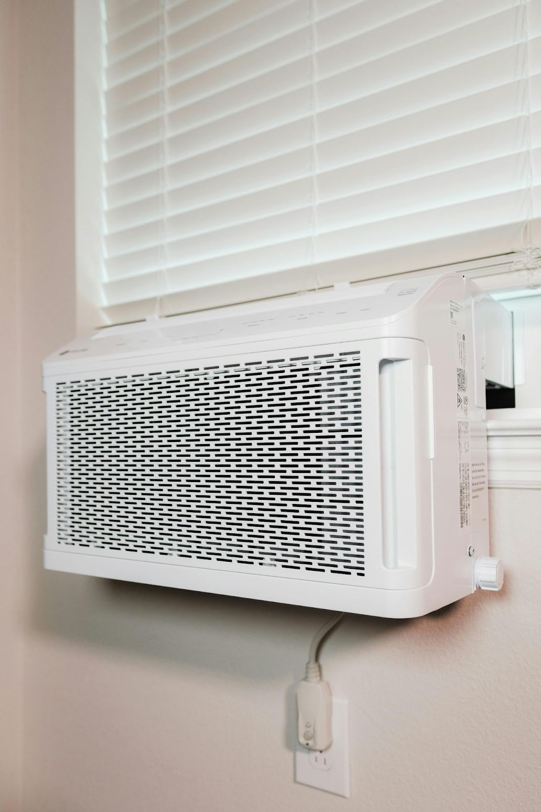 An indoor A/C unit plugged into an outlet on a wall