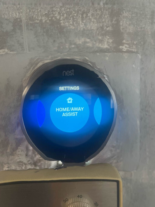 A picture of a smart thermostat on a wall