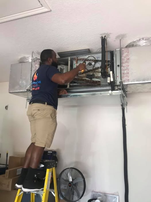 An air conditioning repair technician working on an indoor air conditioning unit's circuit breaker