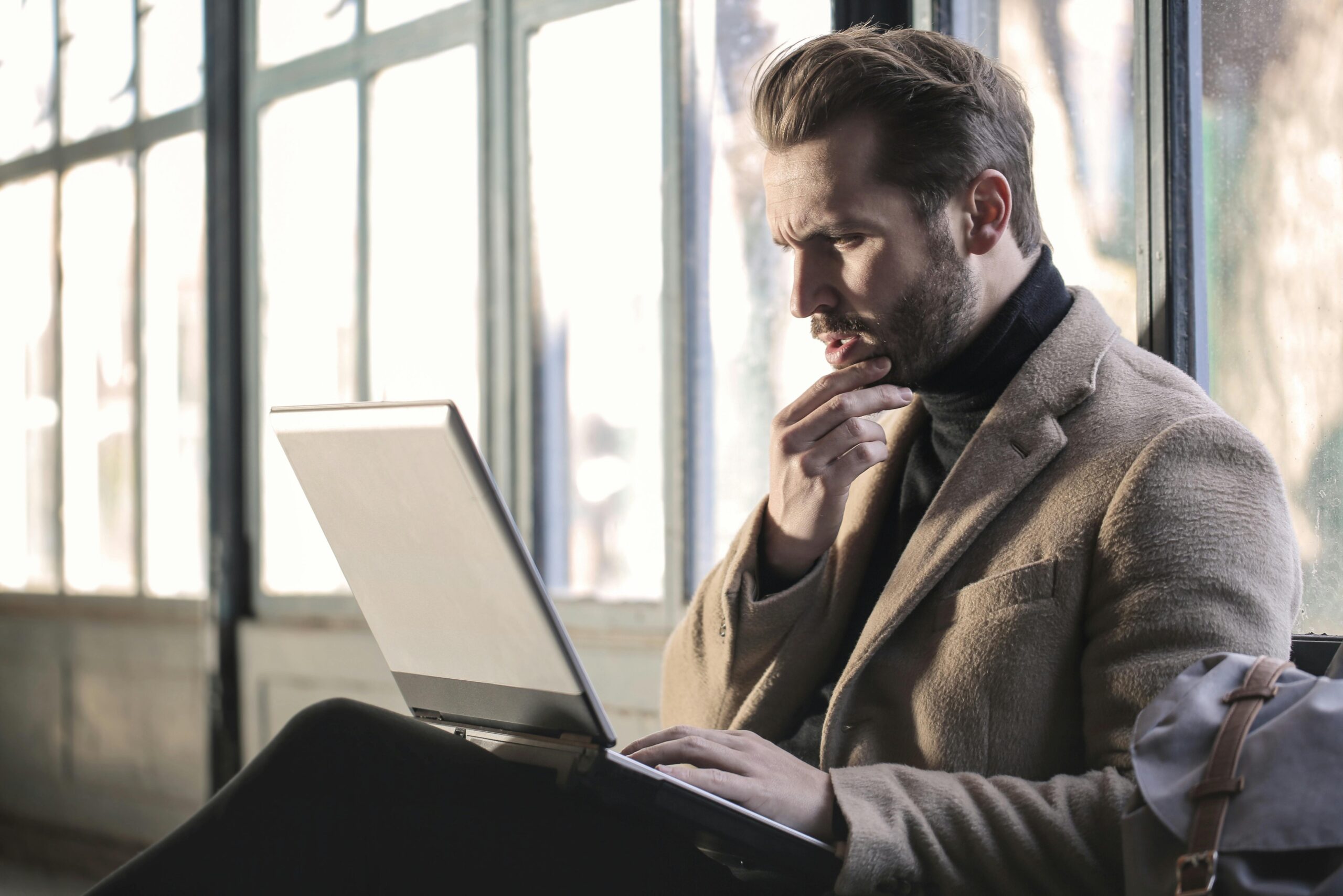 A picture of a person thinking while sitting and researching something on the computer