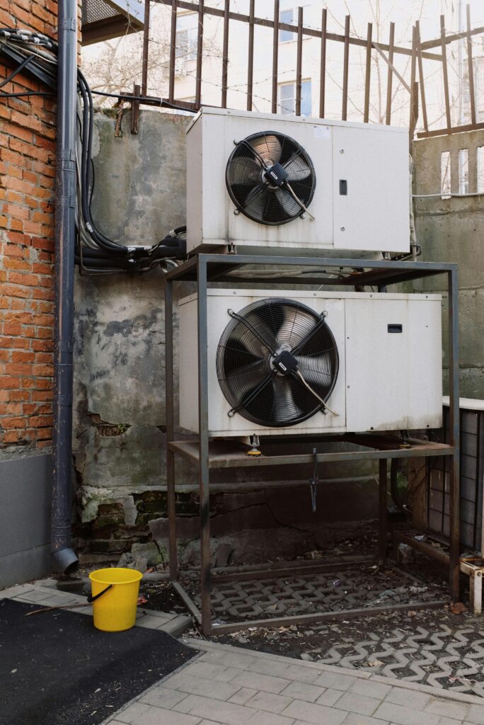 Older air conditioner units leaking water outside of a building